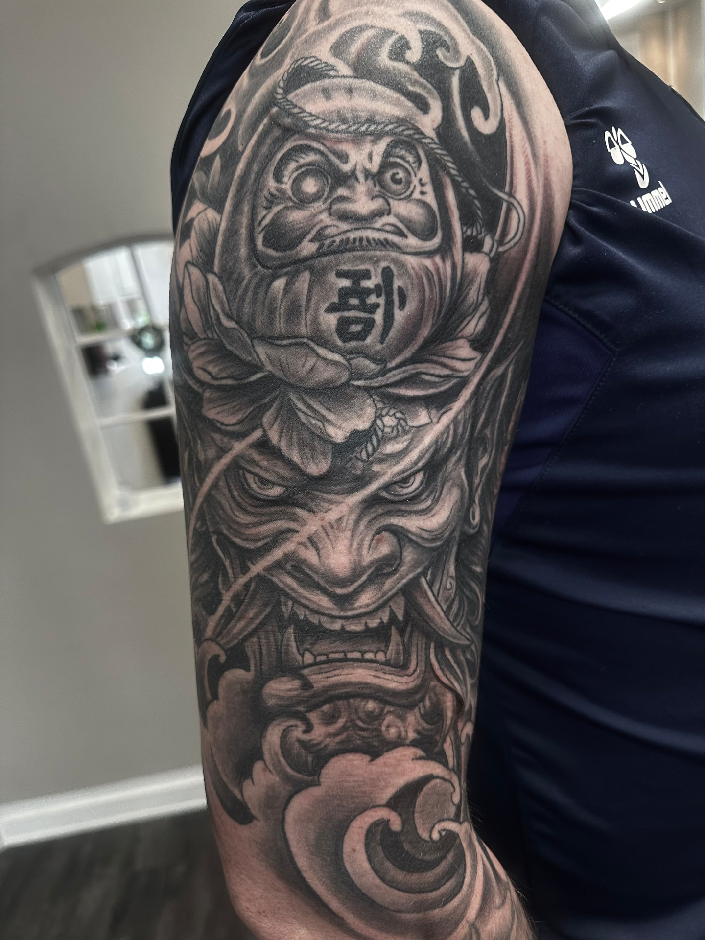 Japansk inspireret sleeve i sort og grå med daruma, hannya-maske og bølger