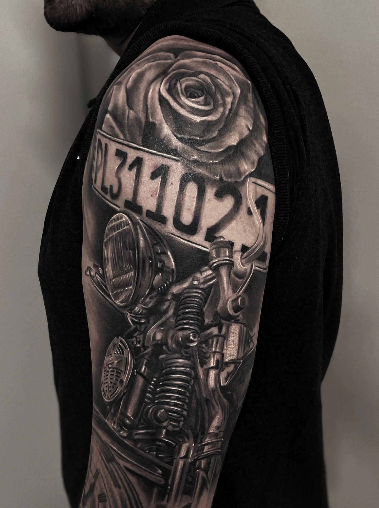 Black and grey overarmstatovering med motorcykel, nummerplade og rose