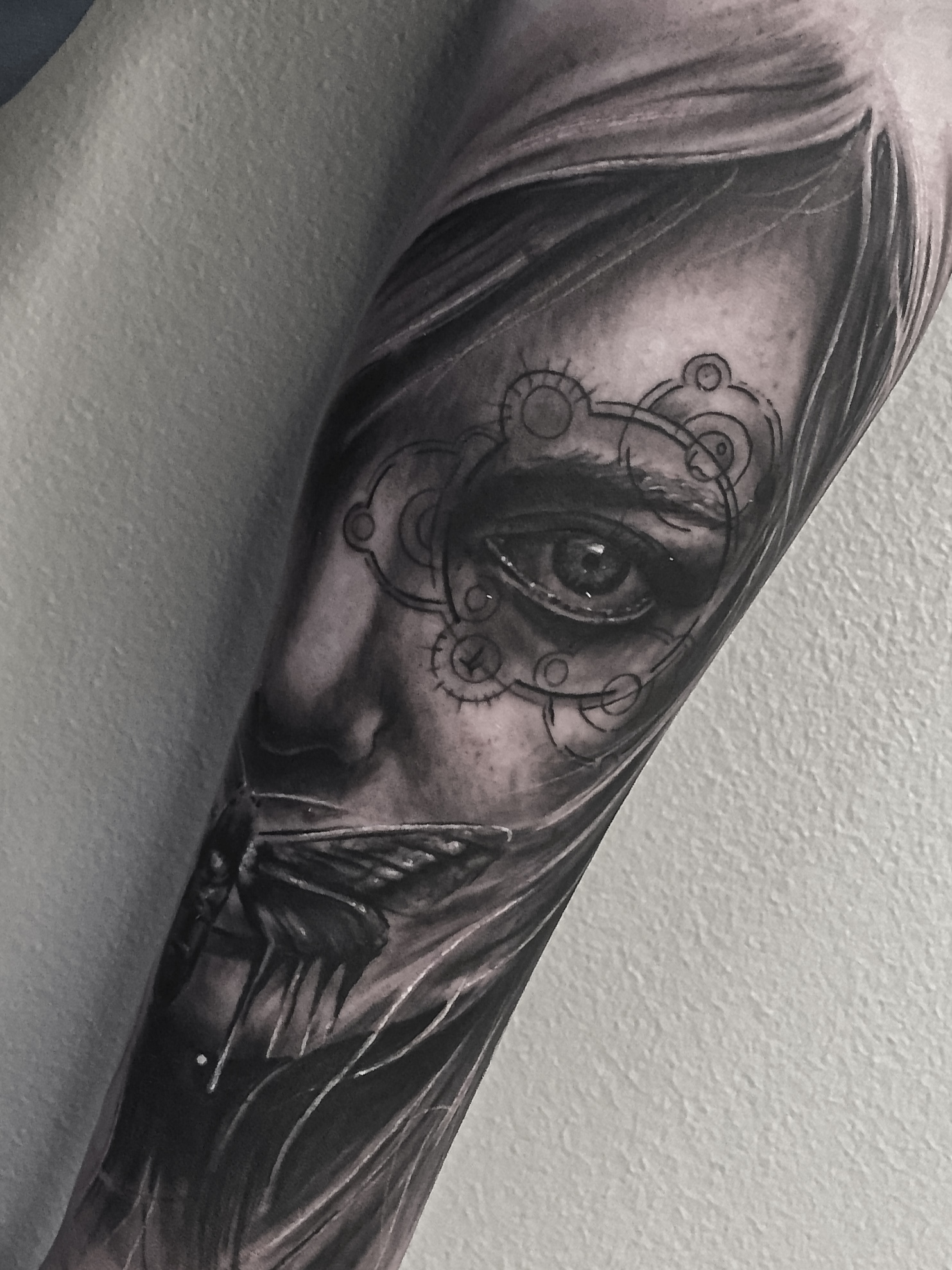 Black and grey tatovering af kvindeansigt med sugar skull-mønster og øje på overarm