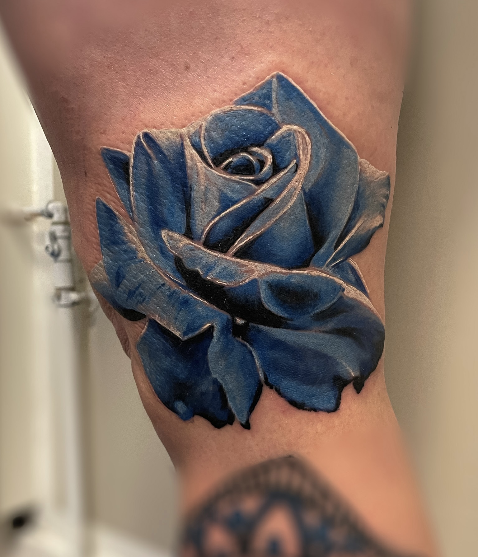 Farvetatovering af blå rose med dybde og skygger på arm