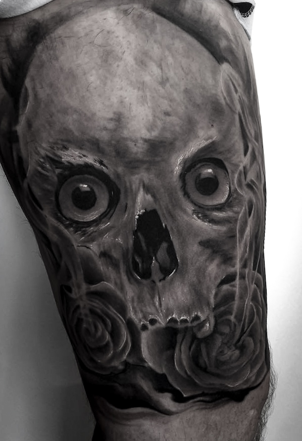 Black and grey tatovering af realistisk kranie med øjne og roser på lår
