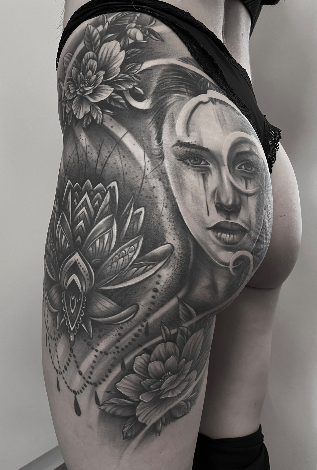Black and grey hoftetatovering med geishaportræt, lotus og ornamenter