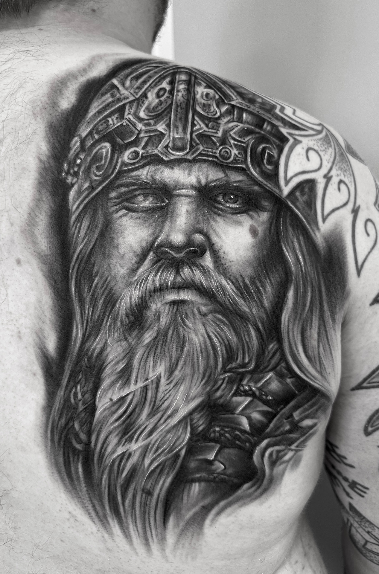 Black and grey rygtatovering med vikingportræt i hjelm og fuldskæg