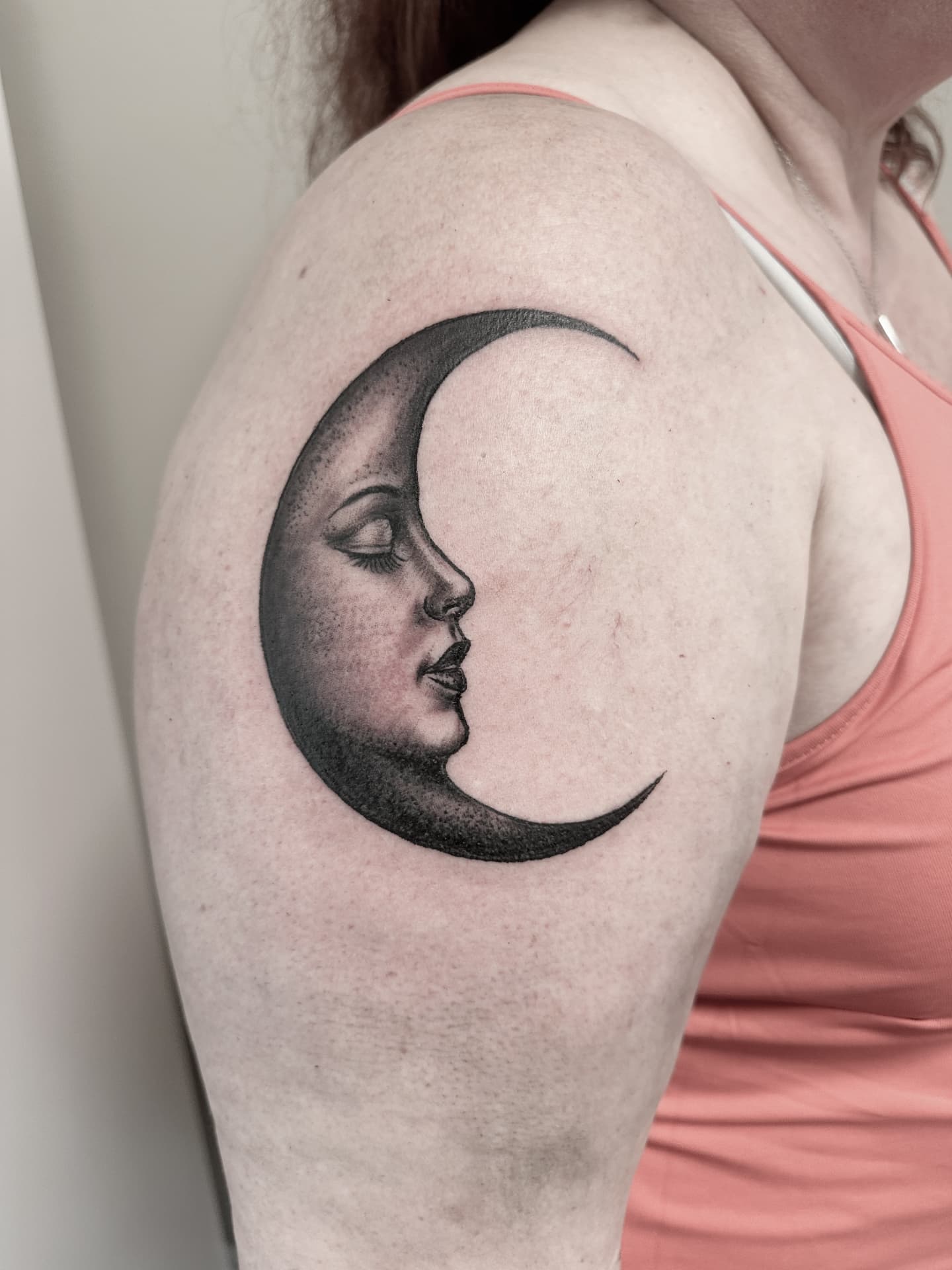Black and grey tatovering af halvmåne med ansigt på overarm
