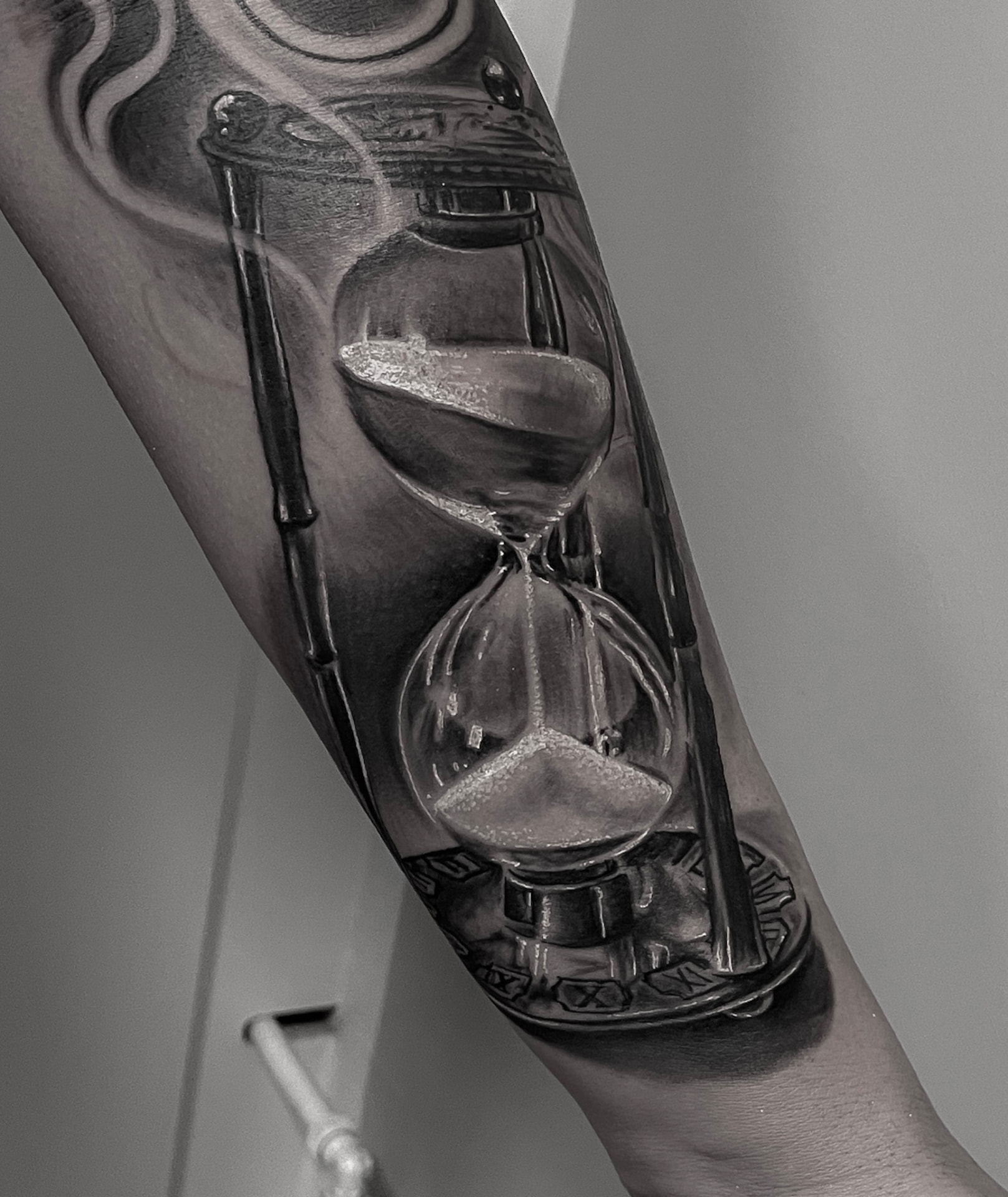 Realistisk black and grey timeglas-tatovering på underarm