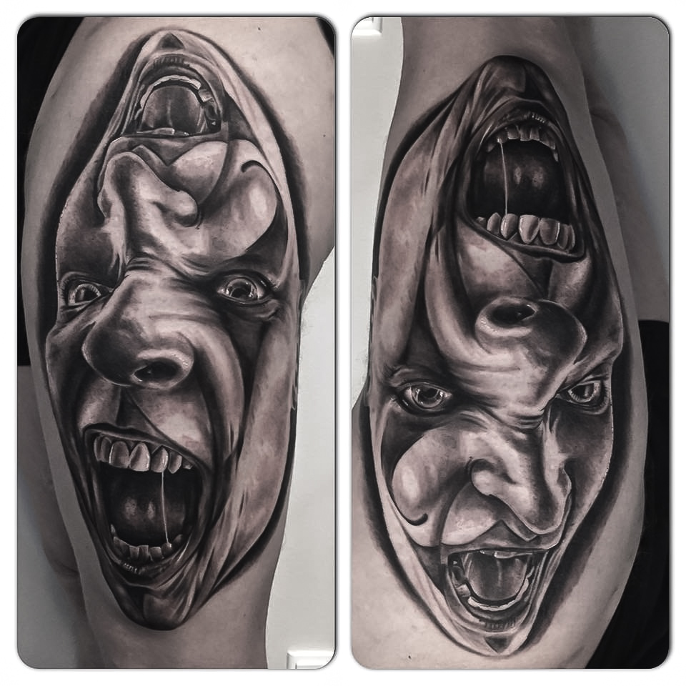 Black and grey tatovering af to skrigende masker med 3D-effekt på lår
