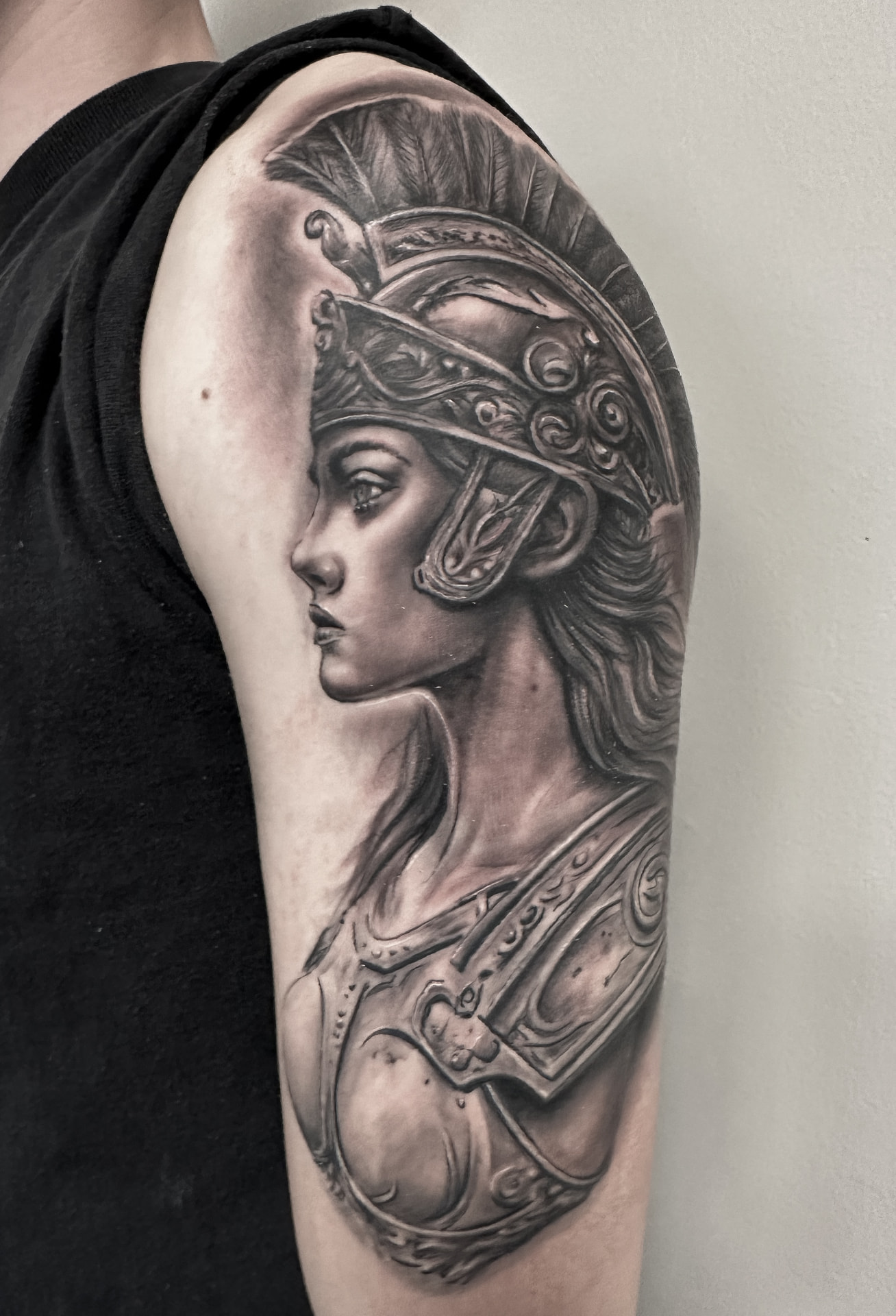Black and grey portræt af Athena med hjelm og rustning på overarm