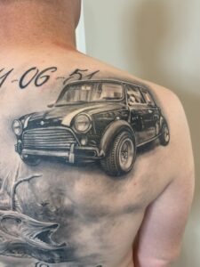 Realistisk tatovering af klassisk Mini Cooper på skulder