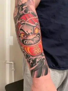 Farverig japansk Daruma-tatovering på underarm- Tattoo Mini