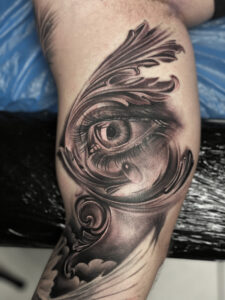 Black and grey tatovering af øje med barokke ornamenter