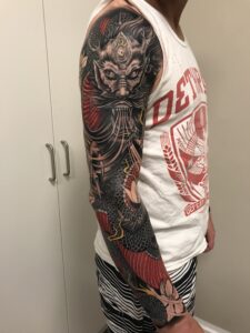 Farverigt japansk sleeve med dæmonmasken Oni, bølger og koi-fisk