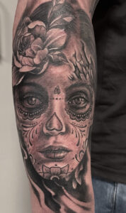 Realistisk sugar skull tatovering af kvindeportræt med blomster