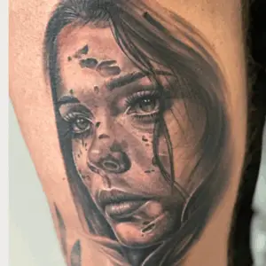 Sort-hvid portræt-tatovering af kvindeansigt med realistiske detaljer og dramatisk skygge.