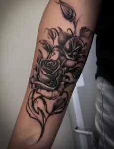 Sort/grå rosetatovering på underarm – detaljeret og realistisk stil