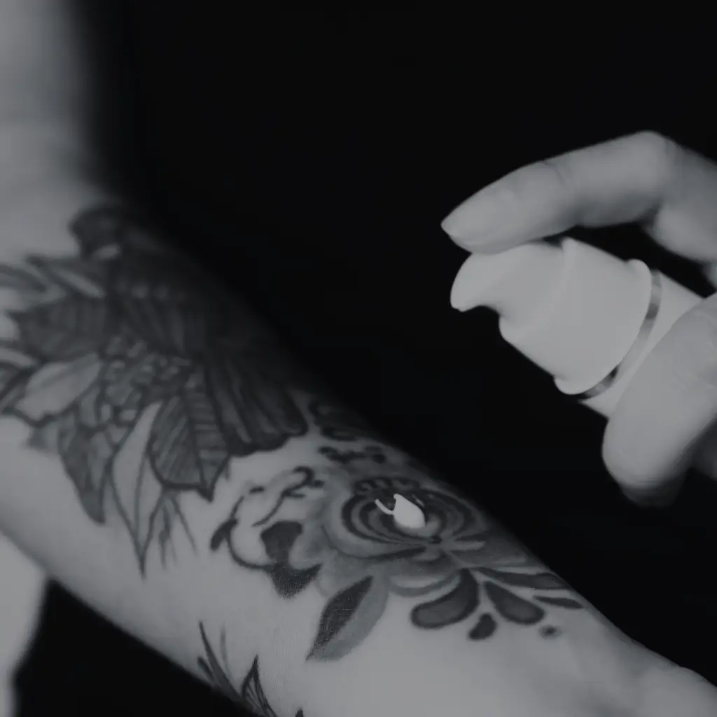 Påføring af aftercare-spray på frisk tatovering for at beskytte huden – Tattoo Mini København