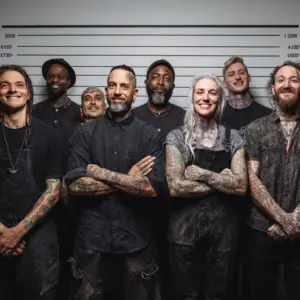 Hvordan vælger man den rigtige tatovør .Gruppe af professionelle tatovøre, med tatoverede arme, stående på række i line up stil. Specialister i Black n Grey realistiske tatoveringer i københavn