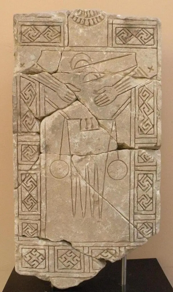 Tatoveringens historie. Antikt stenhugget relief med stiliseret menneskefigur, geometriske mønstre og symbolske hænder, inspireret af oldtidens kunst og ritualer. fra tattoo Mini