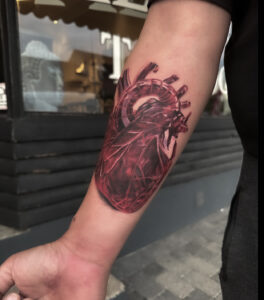 hvordan vælger man den rigtige tatovør. Realistisk anatomisk hjerte tatovering i rød black and grey stil udført af Tattoomini København