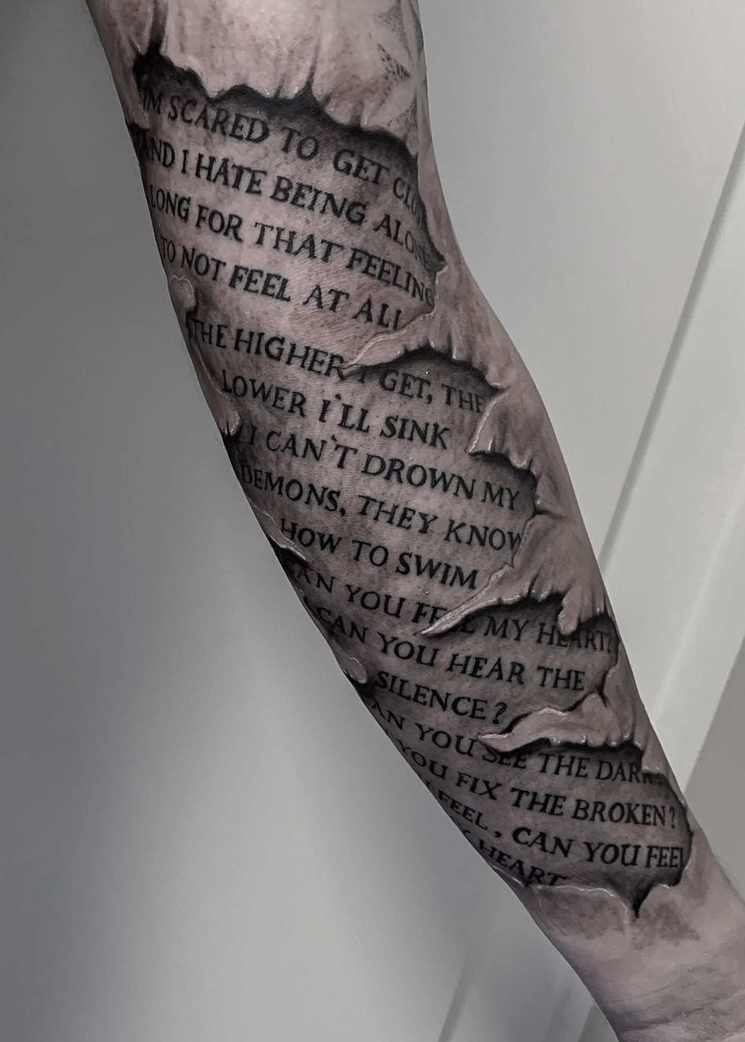 Sleeve tattoo med tekst og realistiske Black and Grey effekter udført af Tattoo Mini i København