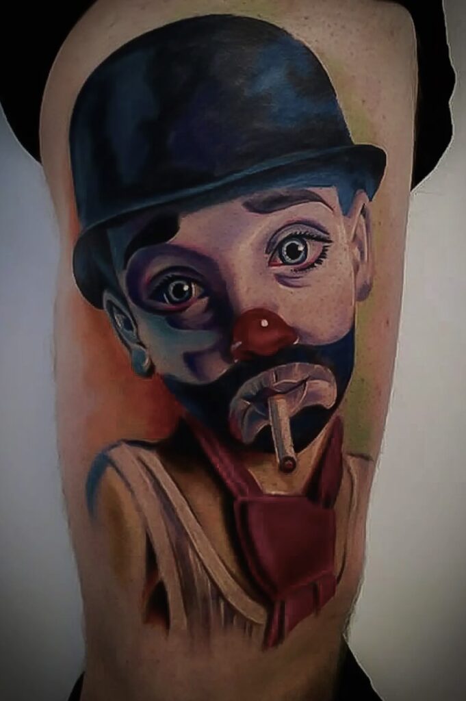 Farverig tatovering af klovn med hat og cigar på overarm