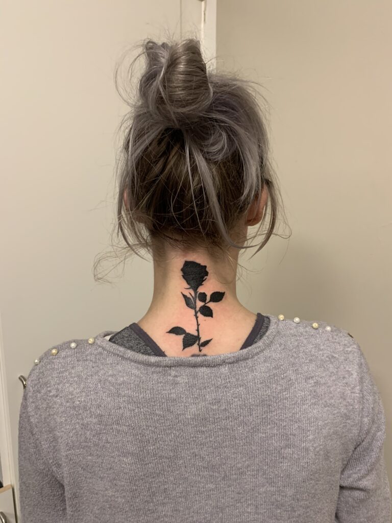 Sort rose cover-up af gammel kors-tatovering i nakken