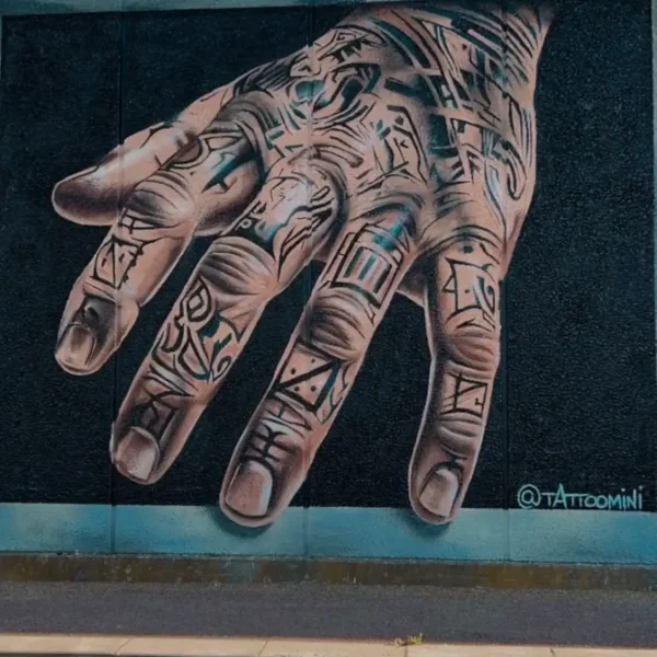 Streetart-vægmaleri af realistisk hånd med symboler